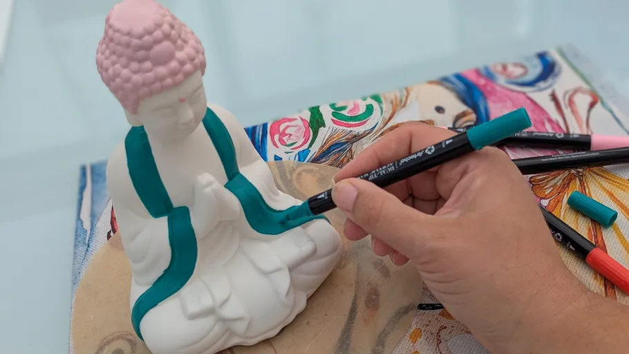 Hand painting Buddha statue with markers.