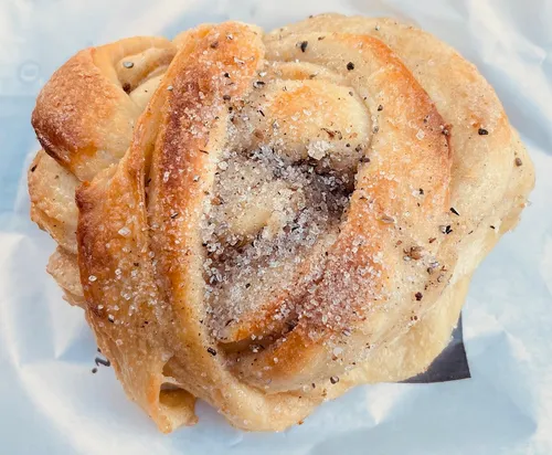 Zimtbrötchen mit Zucker auf Papierhintergrund.