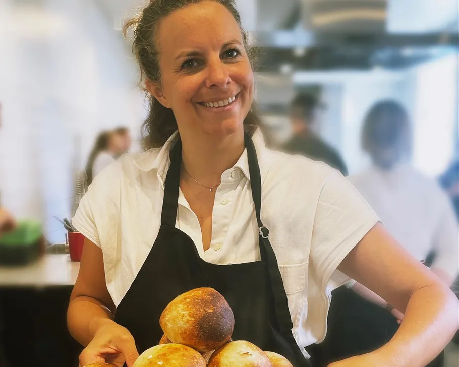 Frau hält Brot in Küchenumgebung.