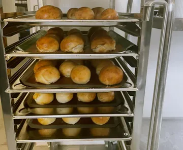 Brötchen kühlen auf Metallgestellen in Küche.