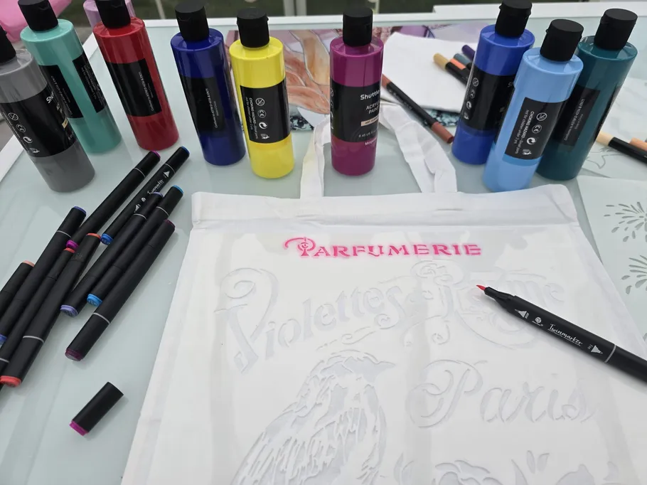 Art supplies and canvas bag on table.