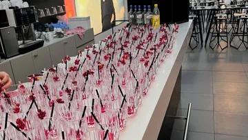 Many drinks with berries on a counter.