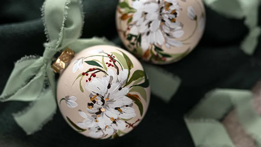 Decorated ornaments with green bows on fabric.