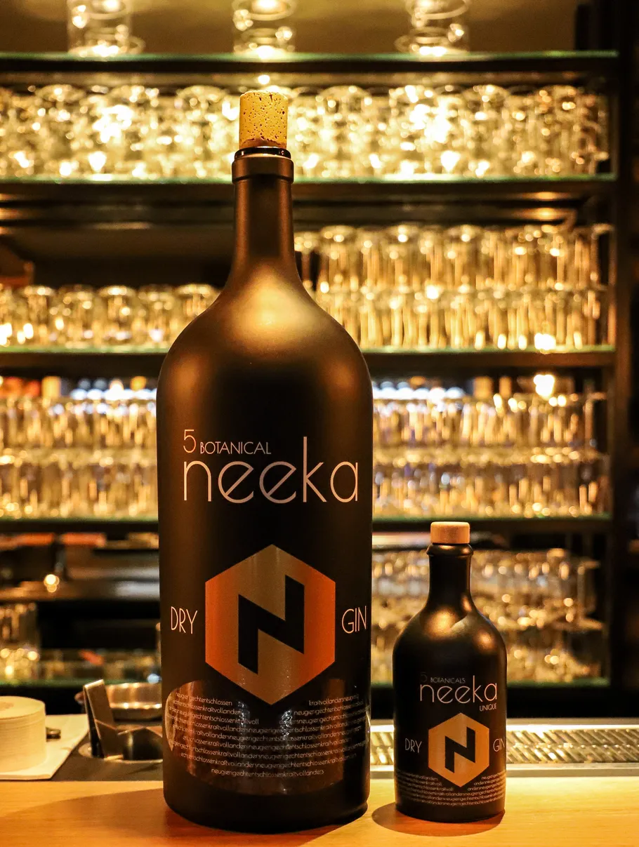 Two Neeka gin bottles on a bar counter.