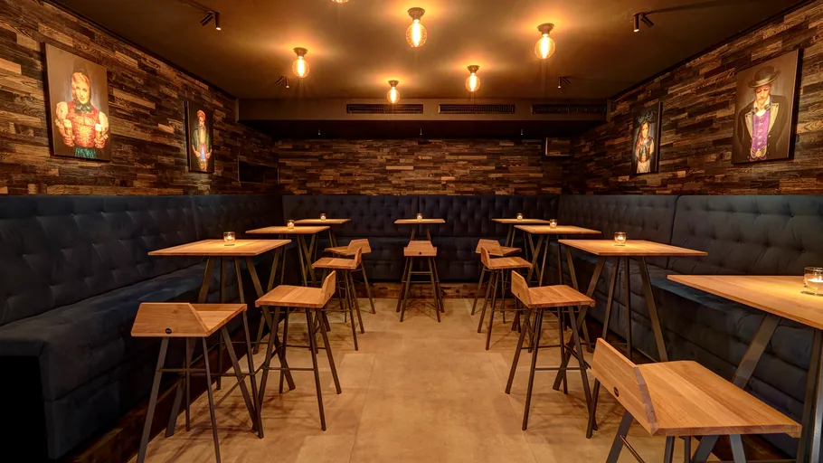 Cozy bar with wood decor and paintings.