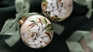 Ornaments with floral designs on dark fabric.