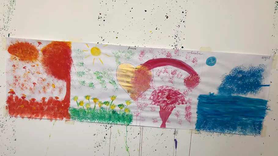Colorful abstract painting on splattered white wall.