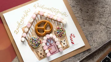 Christmas card with decorated gingerbread house design.