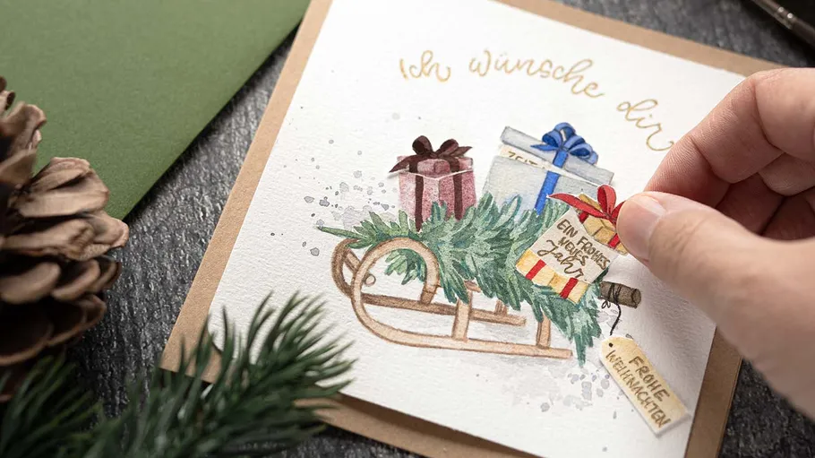 Hand berührt Karte mit Geschenken auf Schlitten.