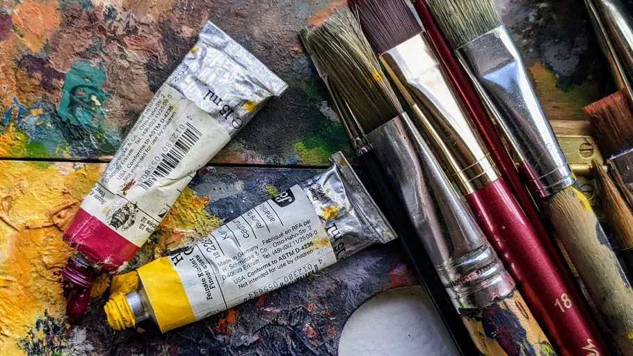 Paint tubes and brushes on a palette.