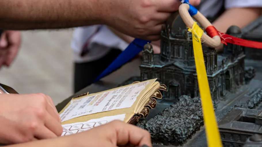 People interact with architectural model outdoors.