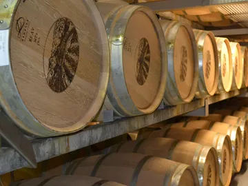 Fässer lagern ordentlich in einem Weinlagerraum.