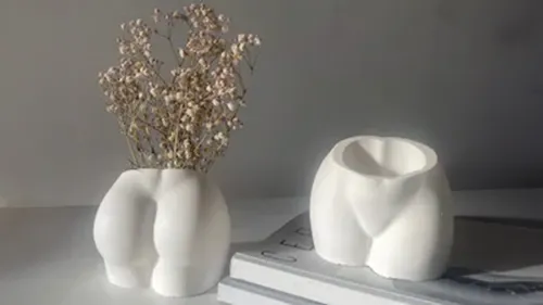 Two white vases shaped like human bottoms.