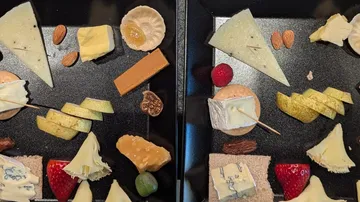 Two trays of assorted cheeses and fruits.