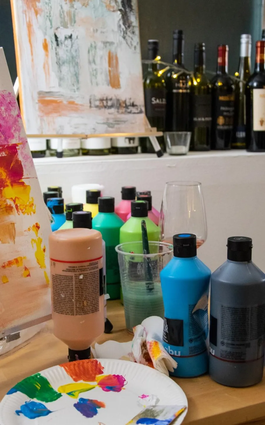 Paint bottles and canvas in art studio.