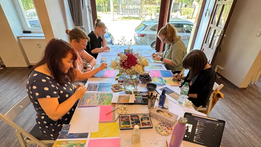 People drawing at a table indoors.