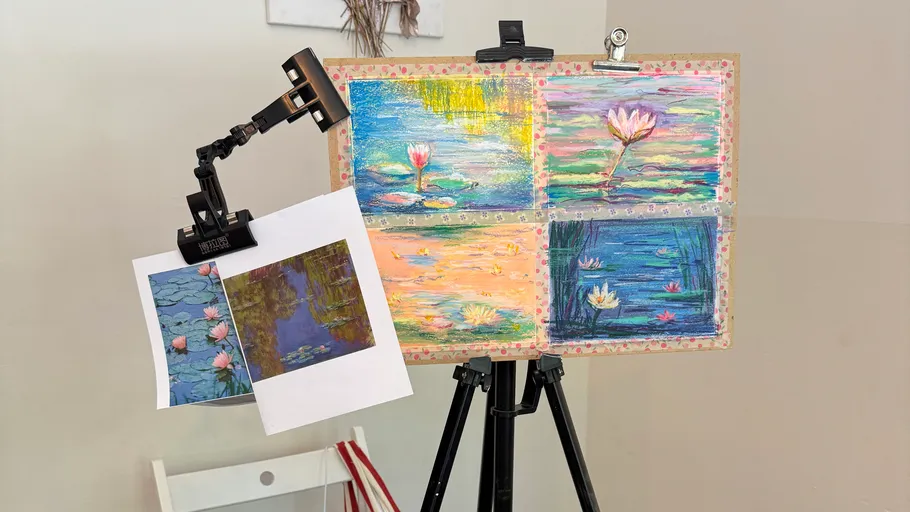Paintings and sketches on an easel indoors.