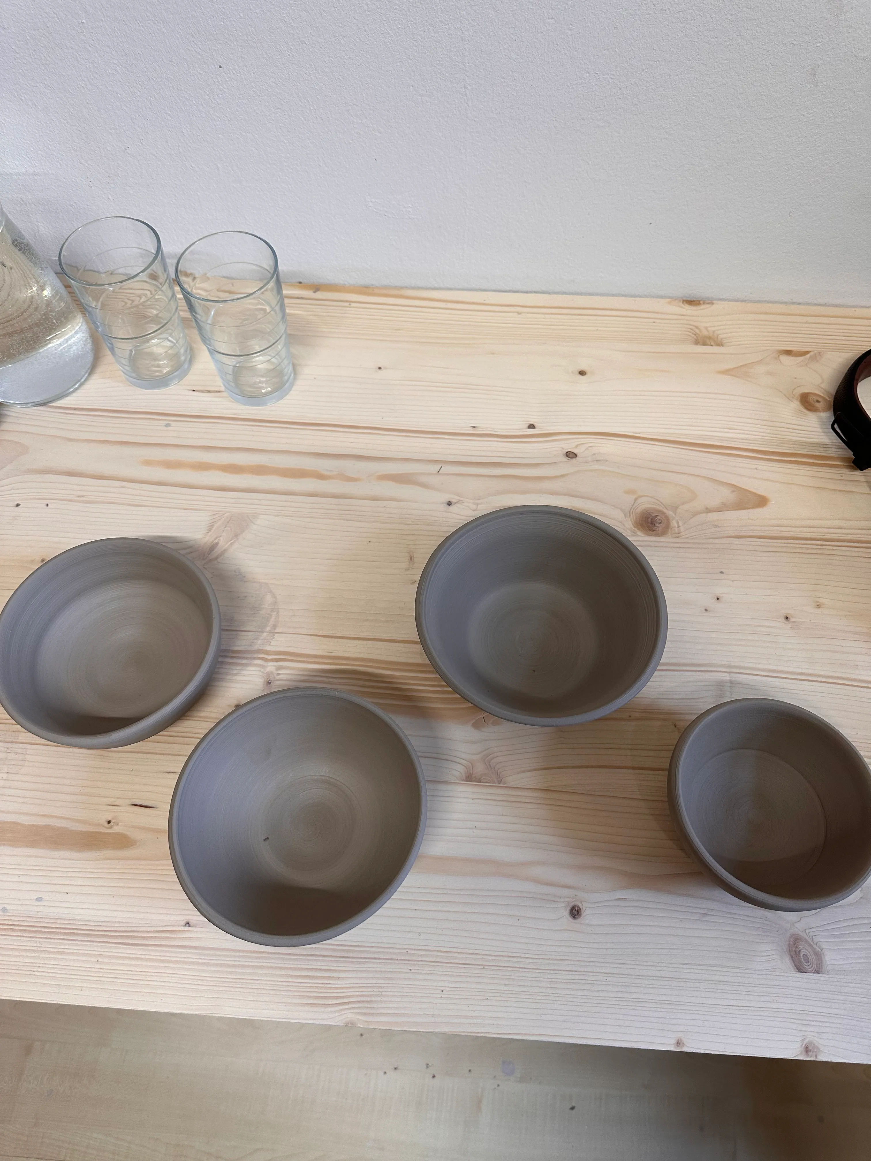 Vier Ton-Schalen auf einem Holztisch.