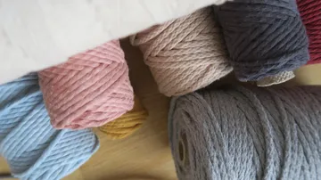Colorful yarn rolls on wooden surface.