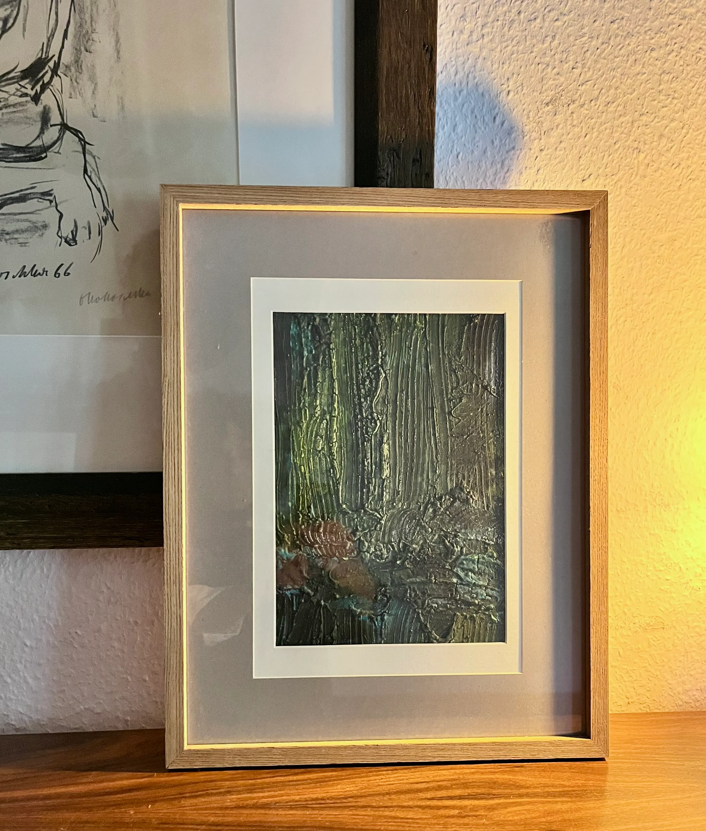 Gerahmtes abstraktes Gemälde auf Holzregal.