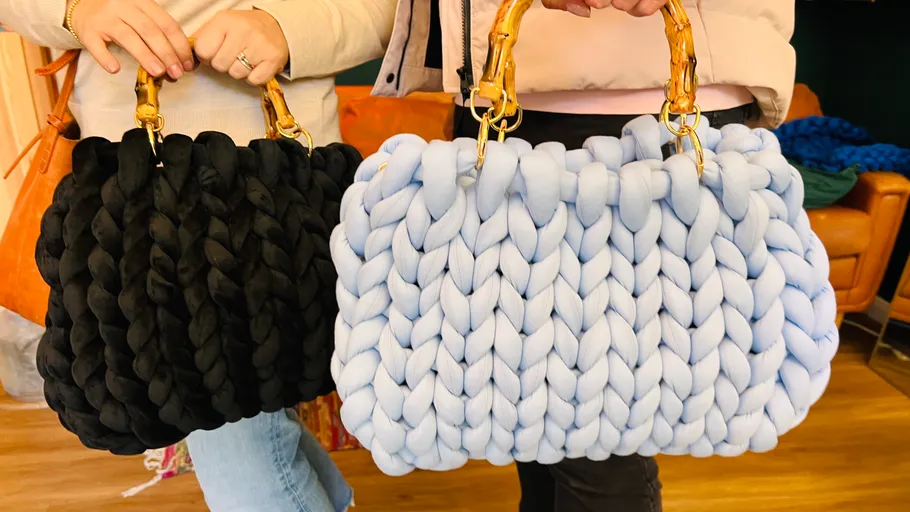 Two handmade knit bags held by people.