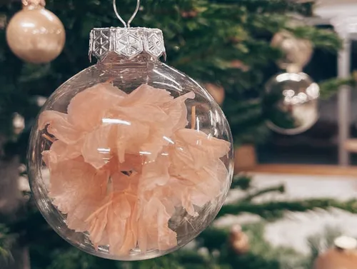 Clear ornament with pink flower inside.