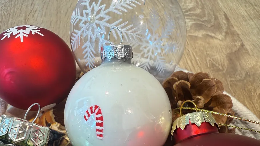 Weihnachtskugeln und Zapfen auf Holz.