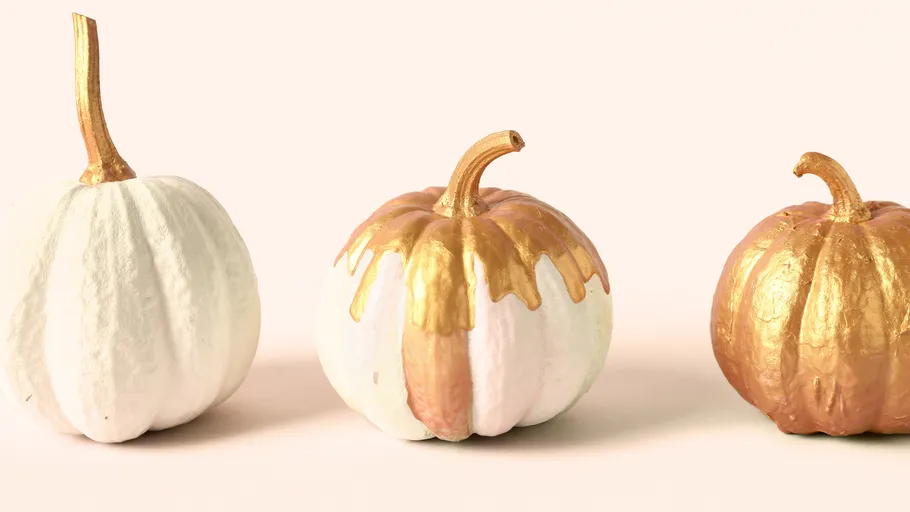 Three pumpkins with gold accents on display.