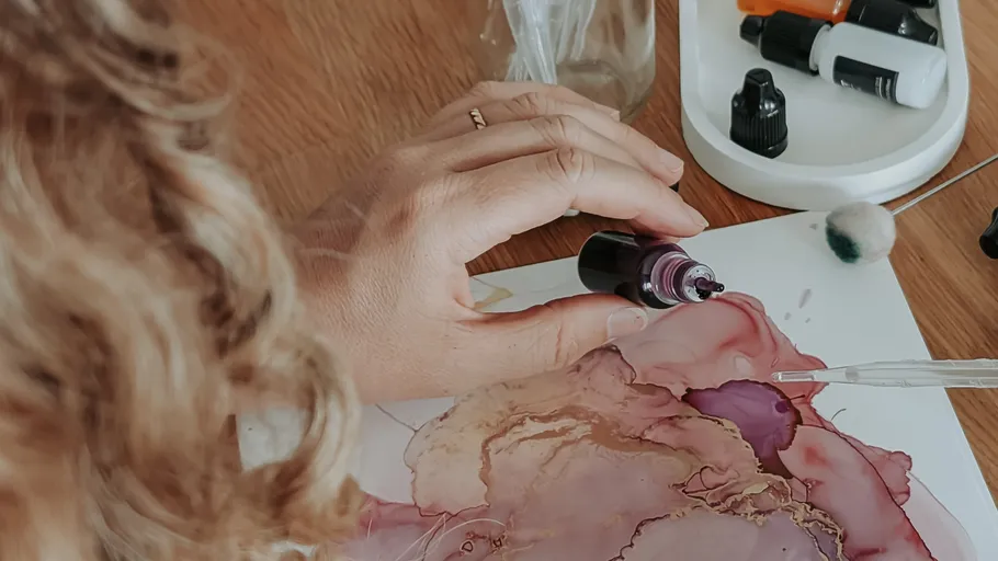 Hand trägt Tinte auf Papier mit Pipette auf.