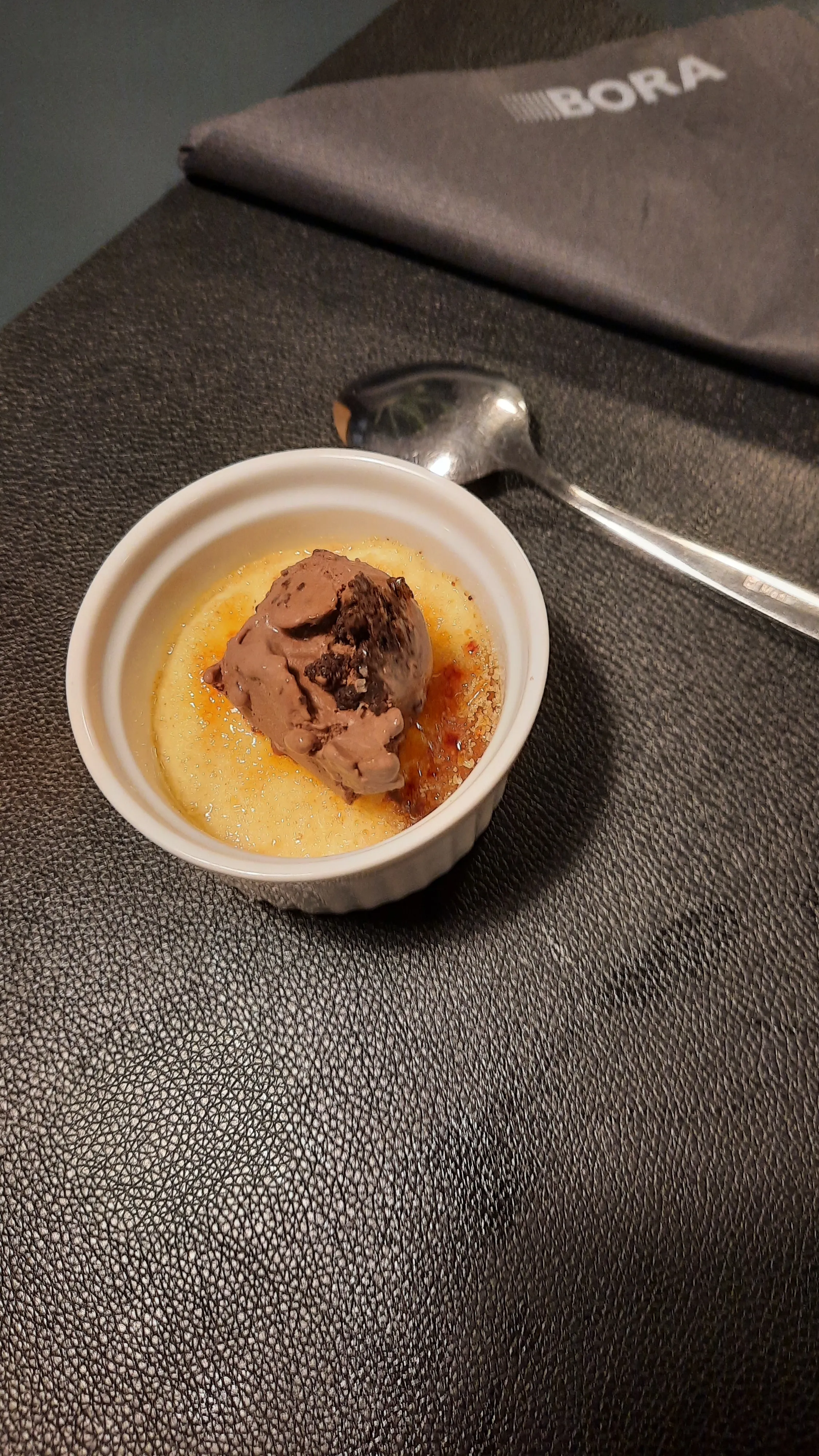 Creme brulee mit Schokoladeneis auf Tisch.