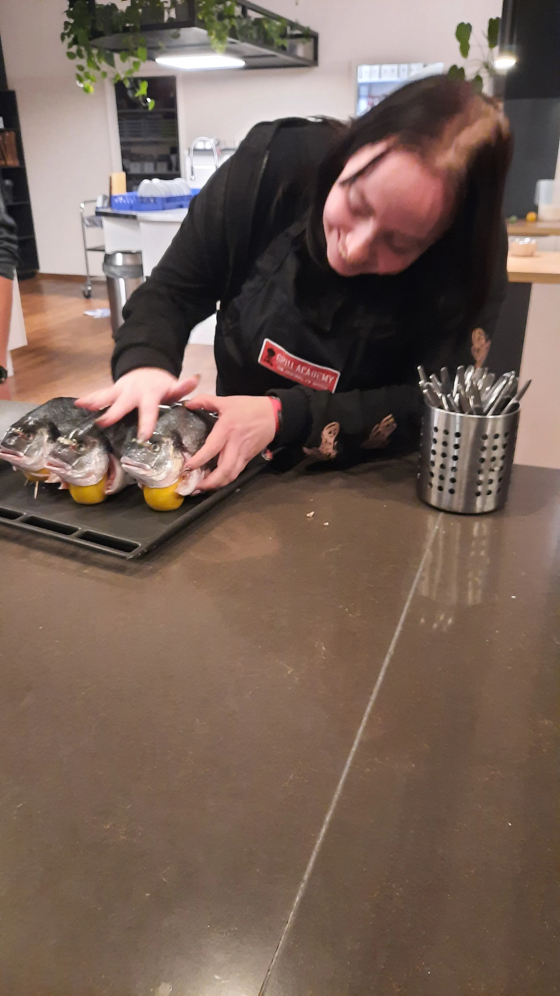 Person bereitet Fisch auf Küchentheke vor.