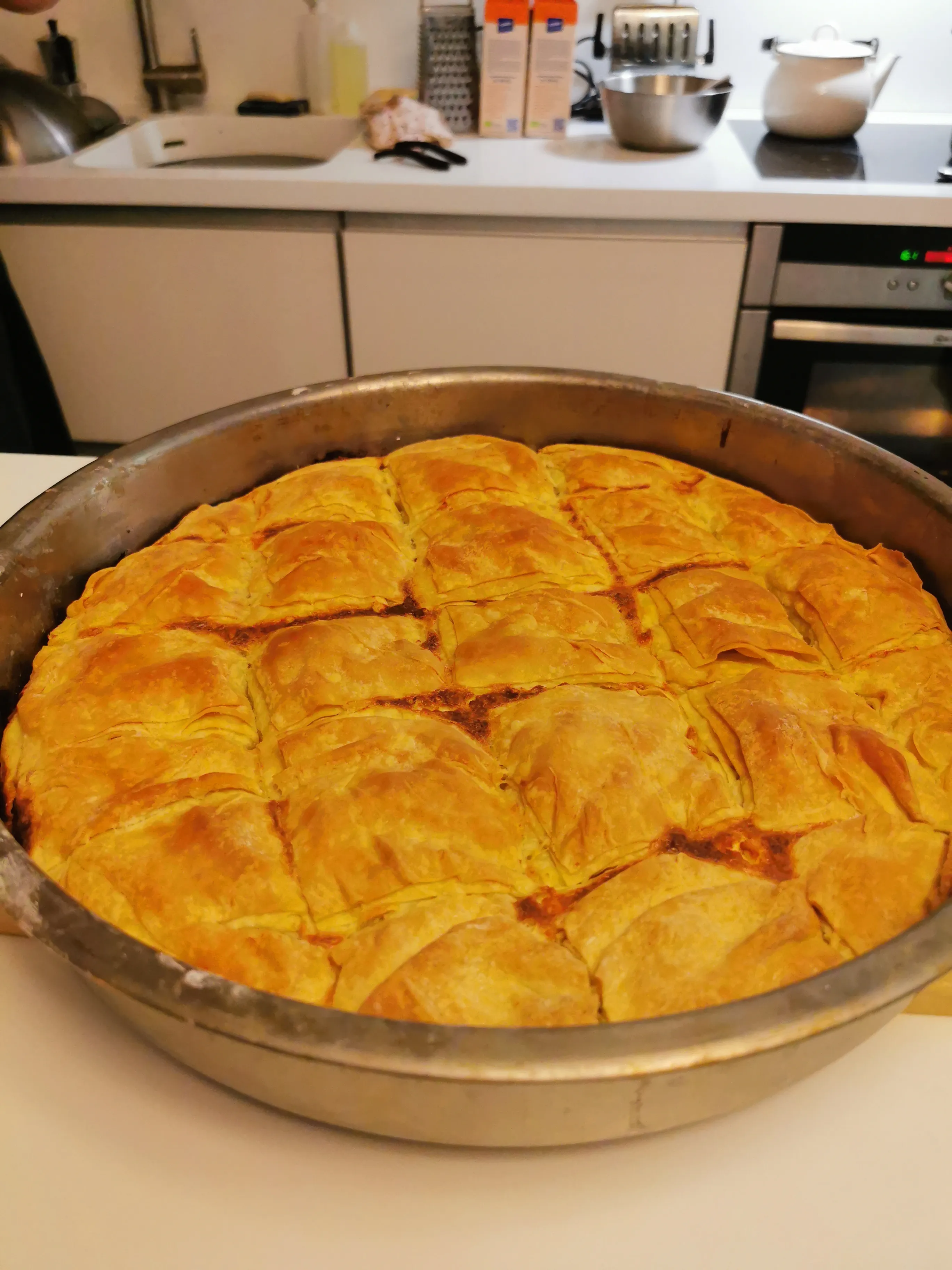 Gebackenes Teiggericht in Metallschale, Küche.