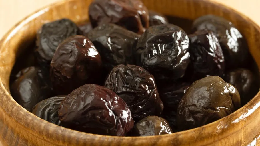 Black olives in a wooden bowl.
