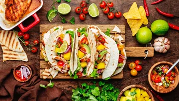 Tacos mit Gemüse auf Holzbrett.