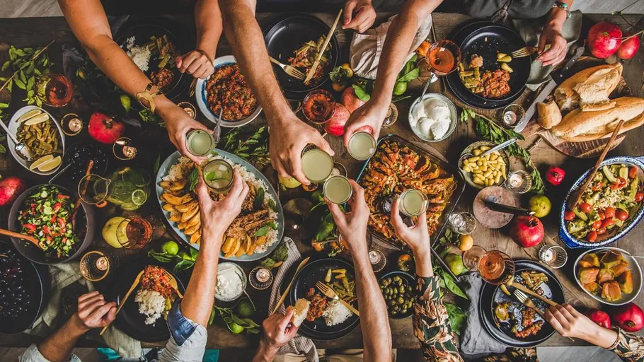 People toasting at a colorful dinner table.