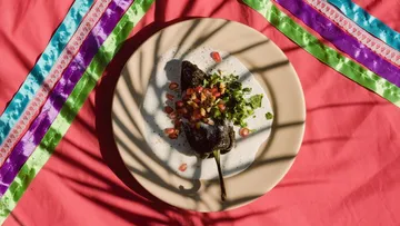 Stuffed pepper with sauce on decorated table.