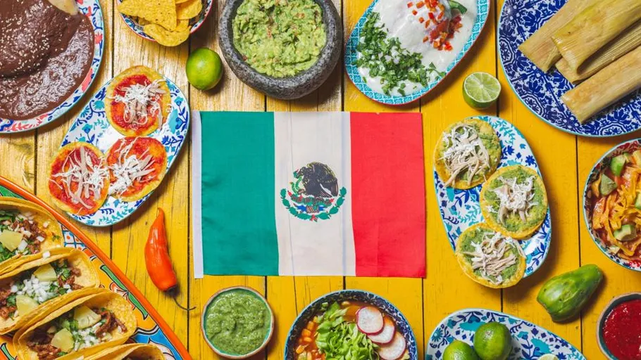 Mexican food and flag on yellow table.