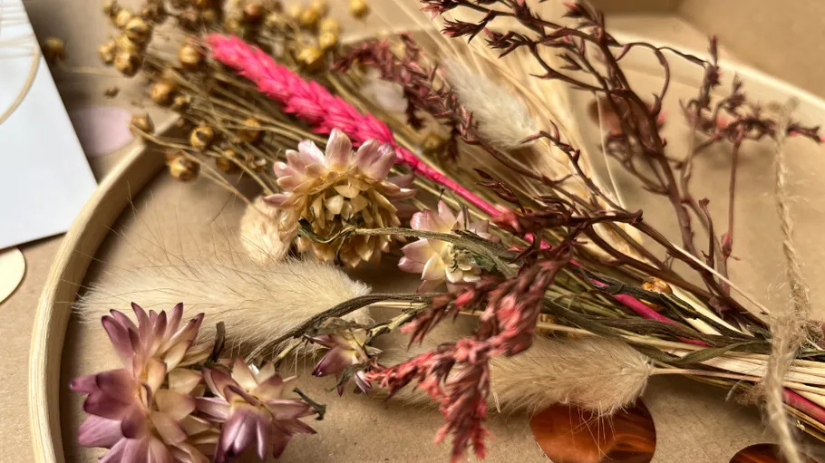 Dried flowers arranged on a wooden tray.