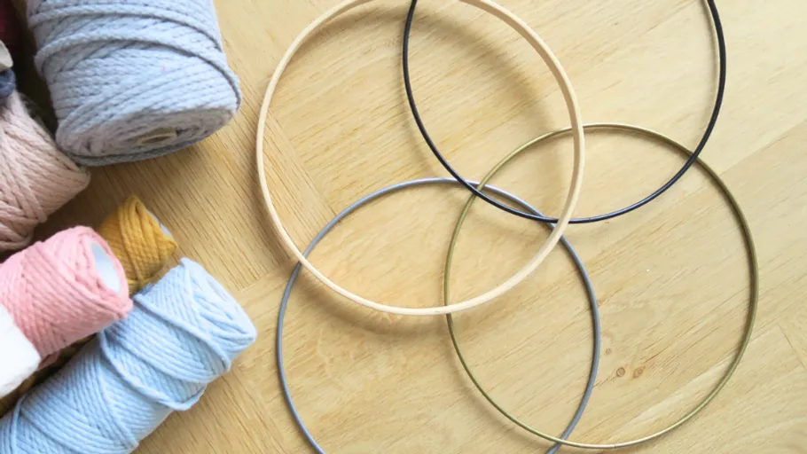 Yarn and metal rings on wooden table.