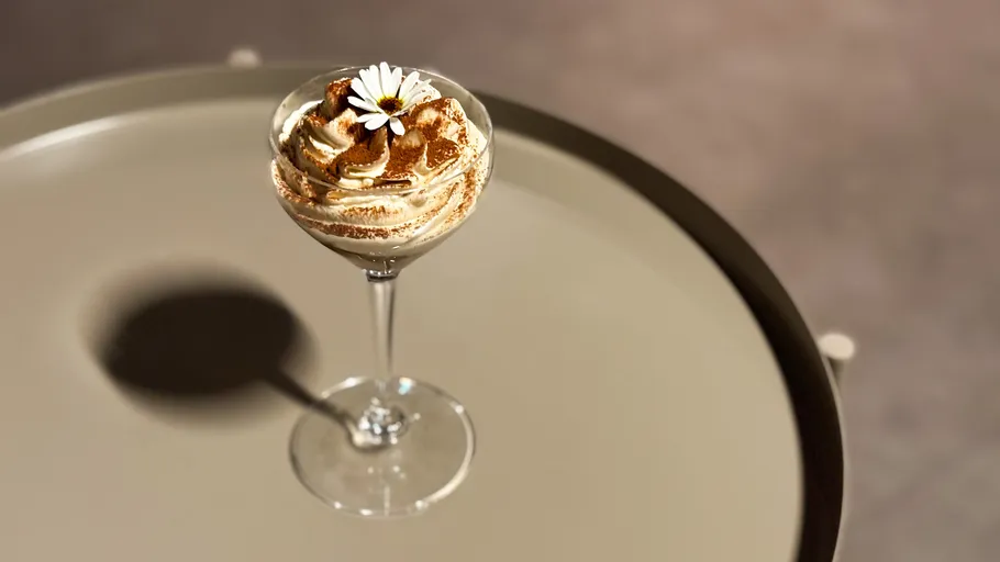 Dessertglas mit Sahne auf einem Tisch.