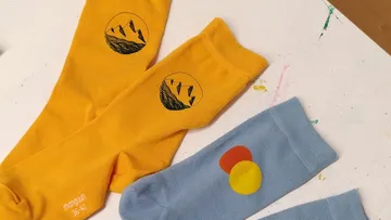 Three colorful socks with unique designs on table.
