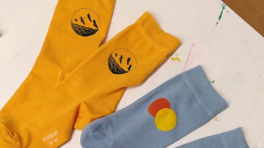 Drei bunte Socken mit einzigartigen Designs auf Tisch.