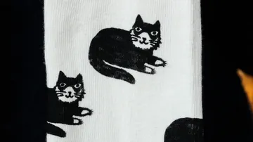Weiße Socke mit schwarzem Katzenmuster.