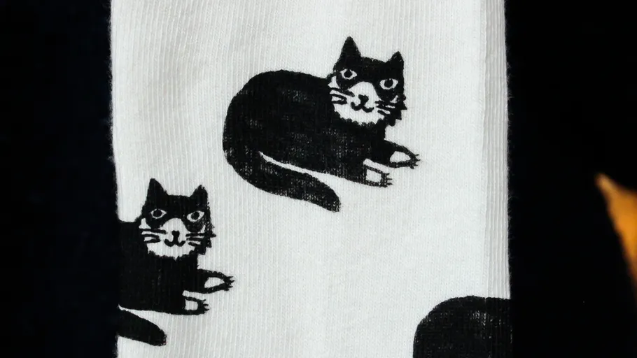 Weiße Socke mit schwarzem Katzenmuster.