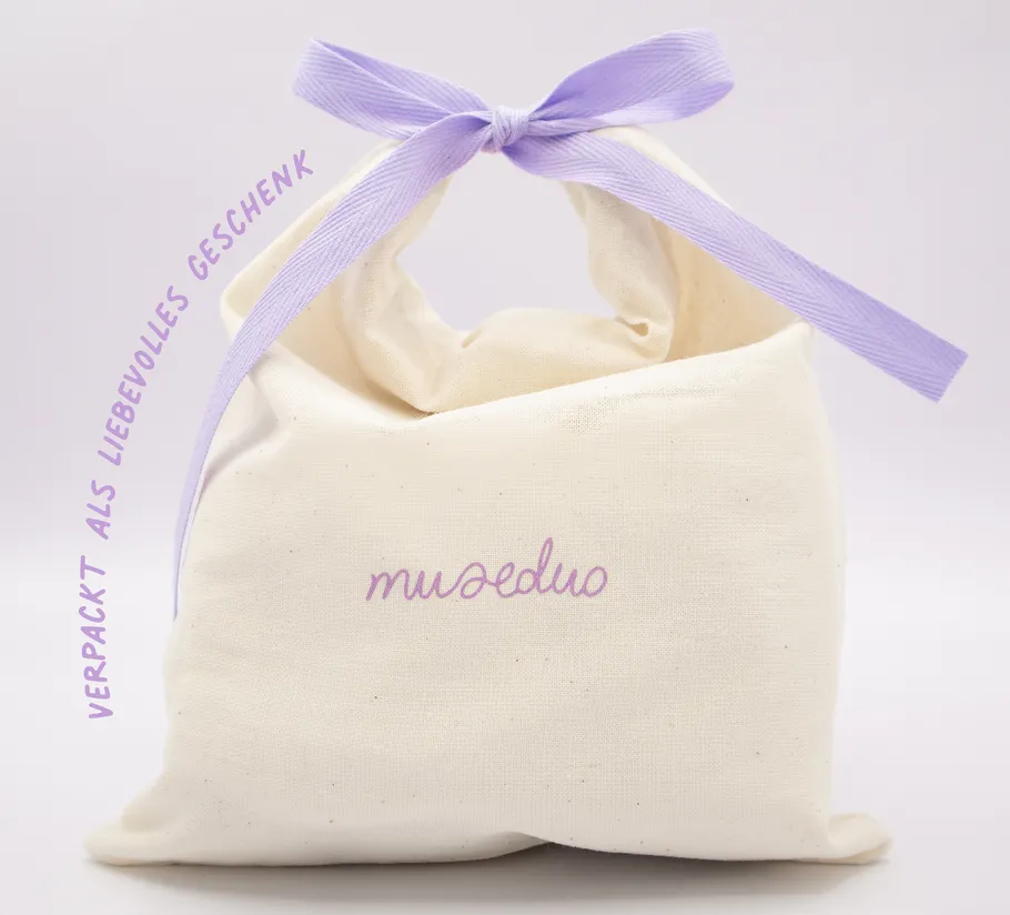 Fabric pouch with purple ribbon, elegant packaging.