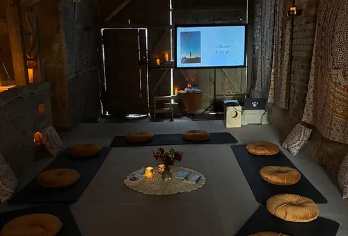 Meditationsraum mit Kissen und gedämpfter Beleuchtung.