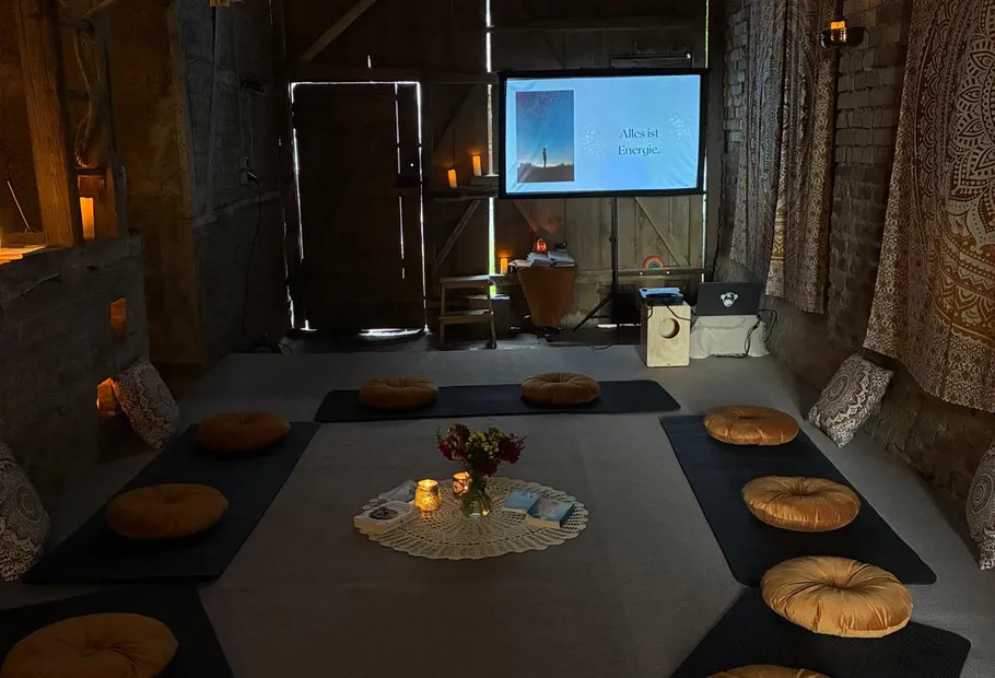 Meditationsraum mit Kissen und gedämpfter Beleuchtung.