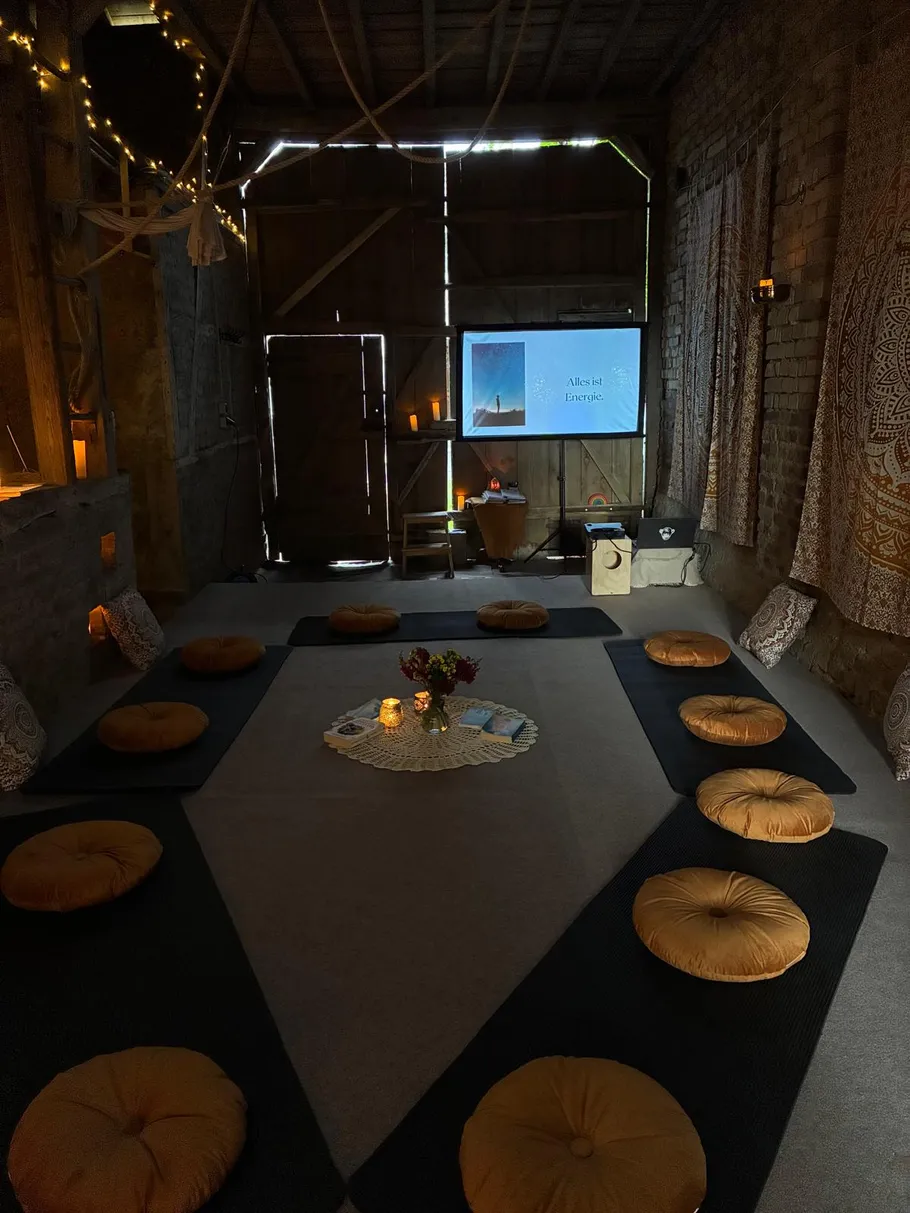 Meditationsraum mit Kissen und gedämpfter Beleuchtung.