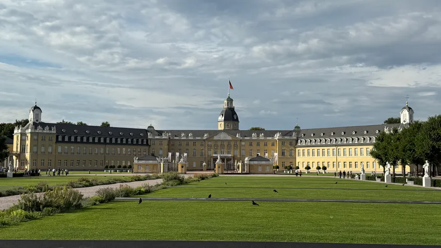 Yellow palace with large courtyard and path.