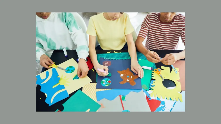 Drei Personen erstellen bunte Papierhandwerke.